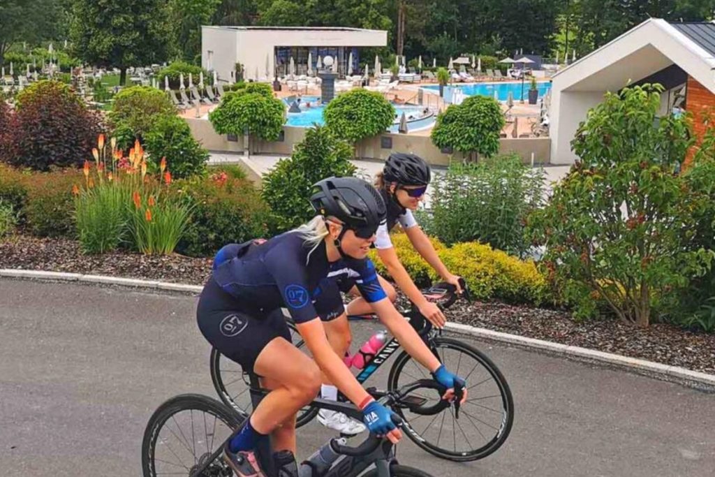 Nora Turner und Anja Gleichweit fahren mit dem Rennrad an der Heiltherme Quellenhotel Bad Waltersdorf vorbei